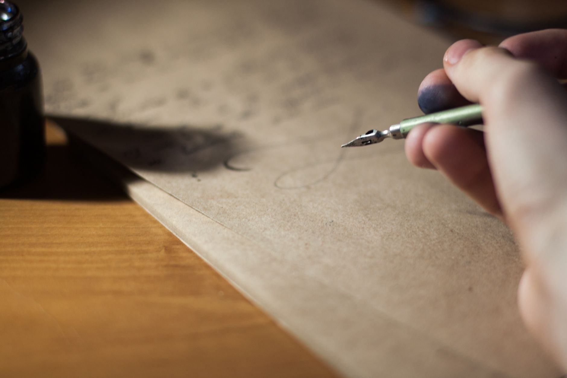 Close-up of a hand writing with a fountain pen on vintage paper
